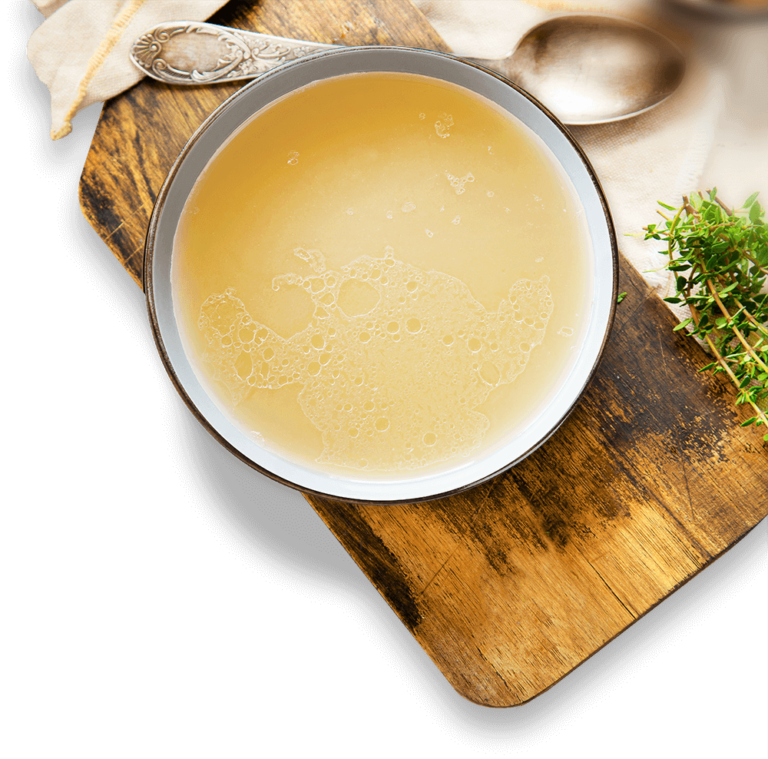 Bowl of Organic Chicken Bone Broth on Cutting Board